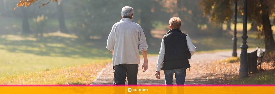 Dos personas mayores caminando tranquilamente por un parque