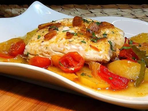 Merluza al horno servida con verduras asadas y una ración moderada de patata